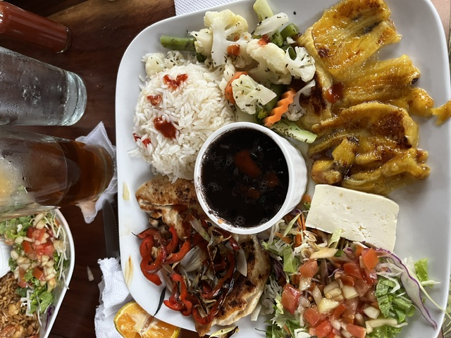 Grilled chicken plate with rice, black beans, plantains and salad