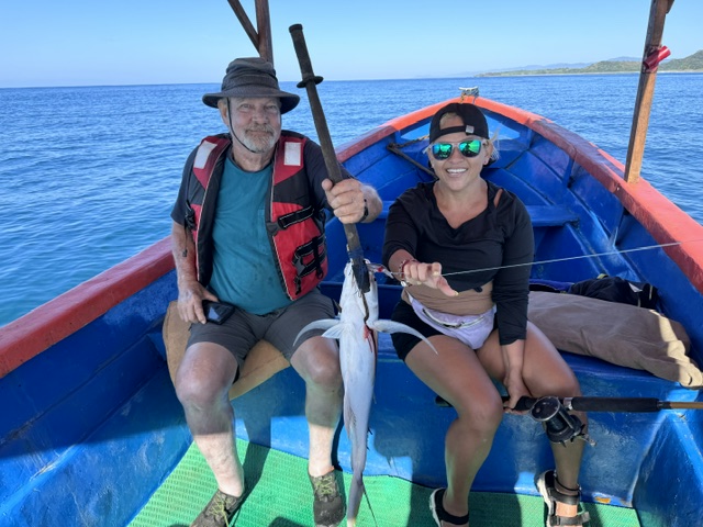 Guest and Scheyla on a fishing boat with a fresh needlefish catch