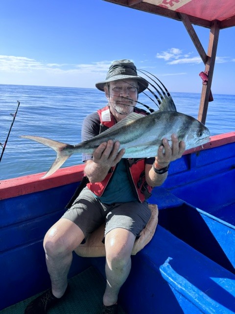 Guest holding a roosterfish caught on a Costa Rica fishing tour